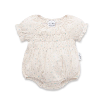 Ivory baby romper with pale blue floral print, bubble fit, frill cuffs, and snap buttons.
