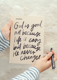 Cream inspirational journal with handwritten 'God is good' cover quote.
