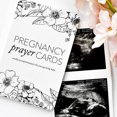 Illustration of a baby in the womb with a prayer card