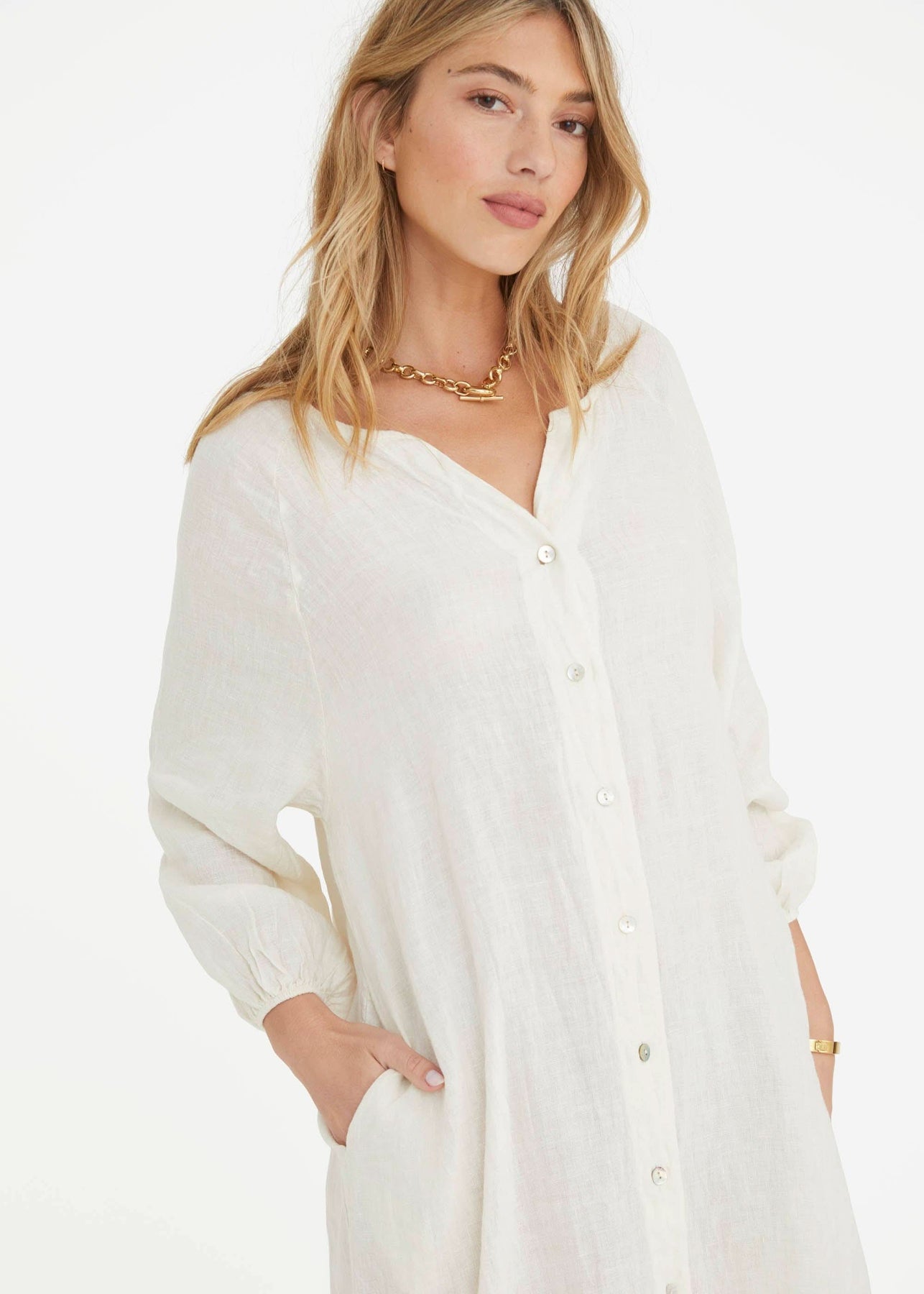 Ecru maternity dress with oversized silhouette, button front, cinched sleeves, and pockets.