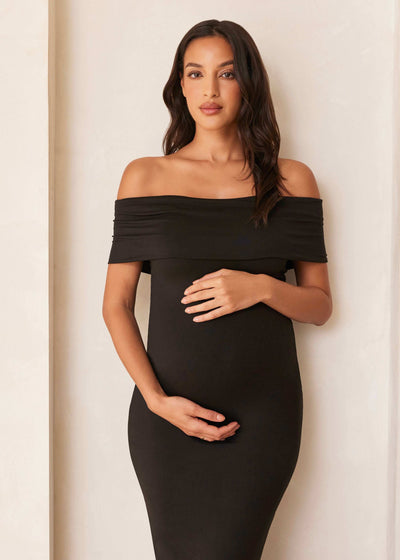 Beautiful woman in a black off-the-shoulder dress with stretchy fabric and elegant design