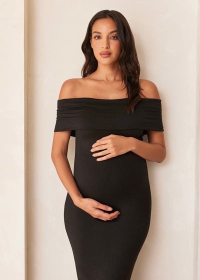 Beautiful woman in a black off-the-shoulder dress with stretchy fabric and elegant design