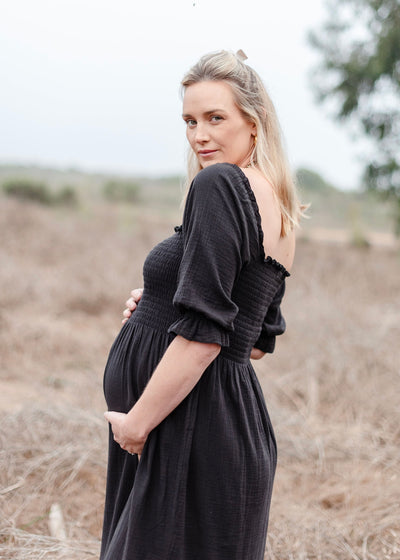 Beautiful black muslin smocked dress with elegant ruffled sleeves and a flowing skirt 