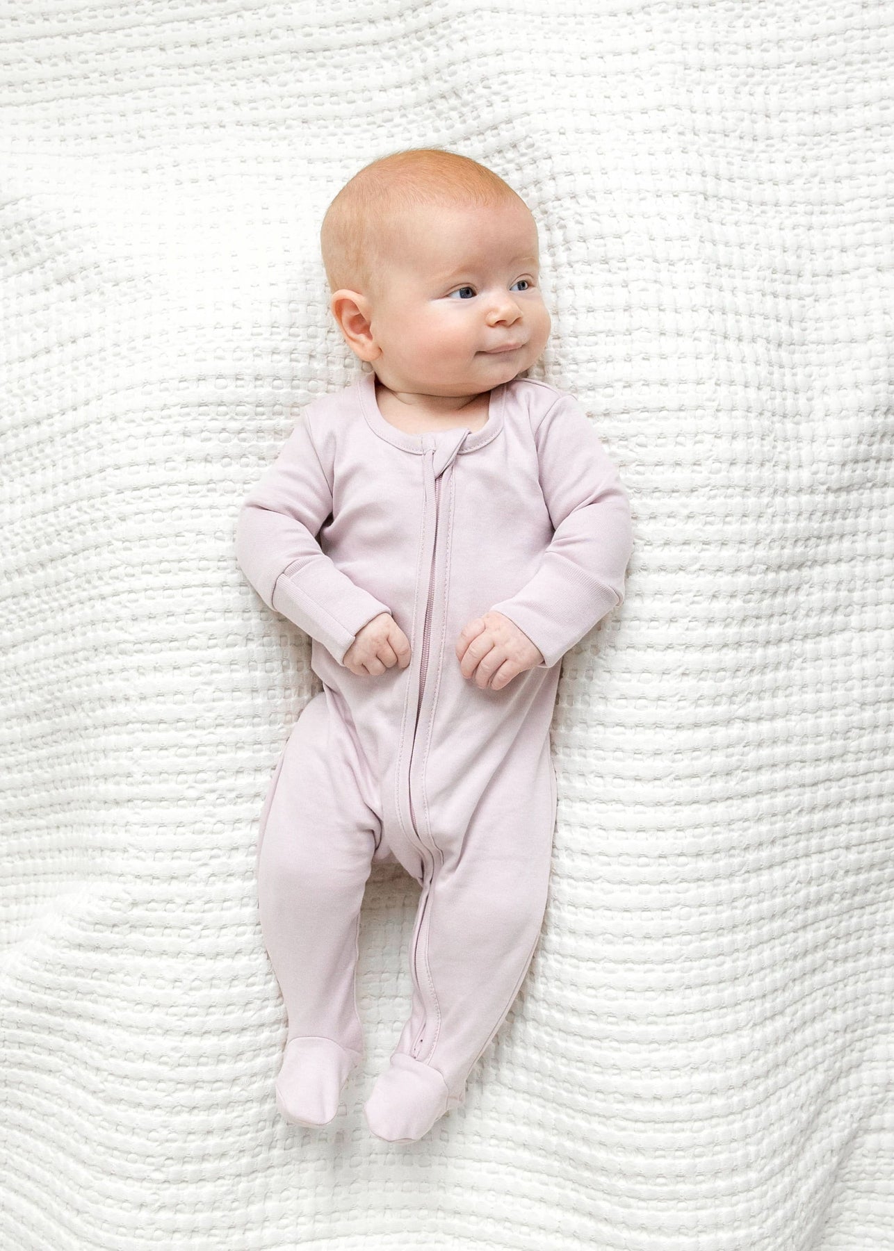 Organic baby sleeper in wisteria with two-way zippers and fold-over cuff mitts.