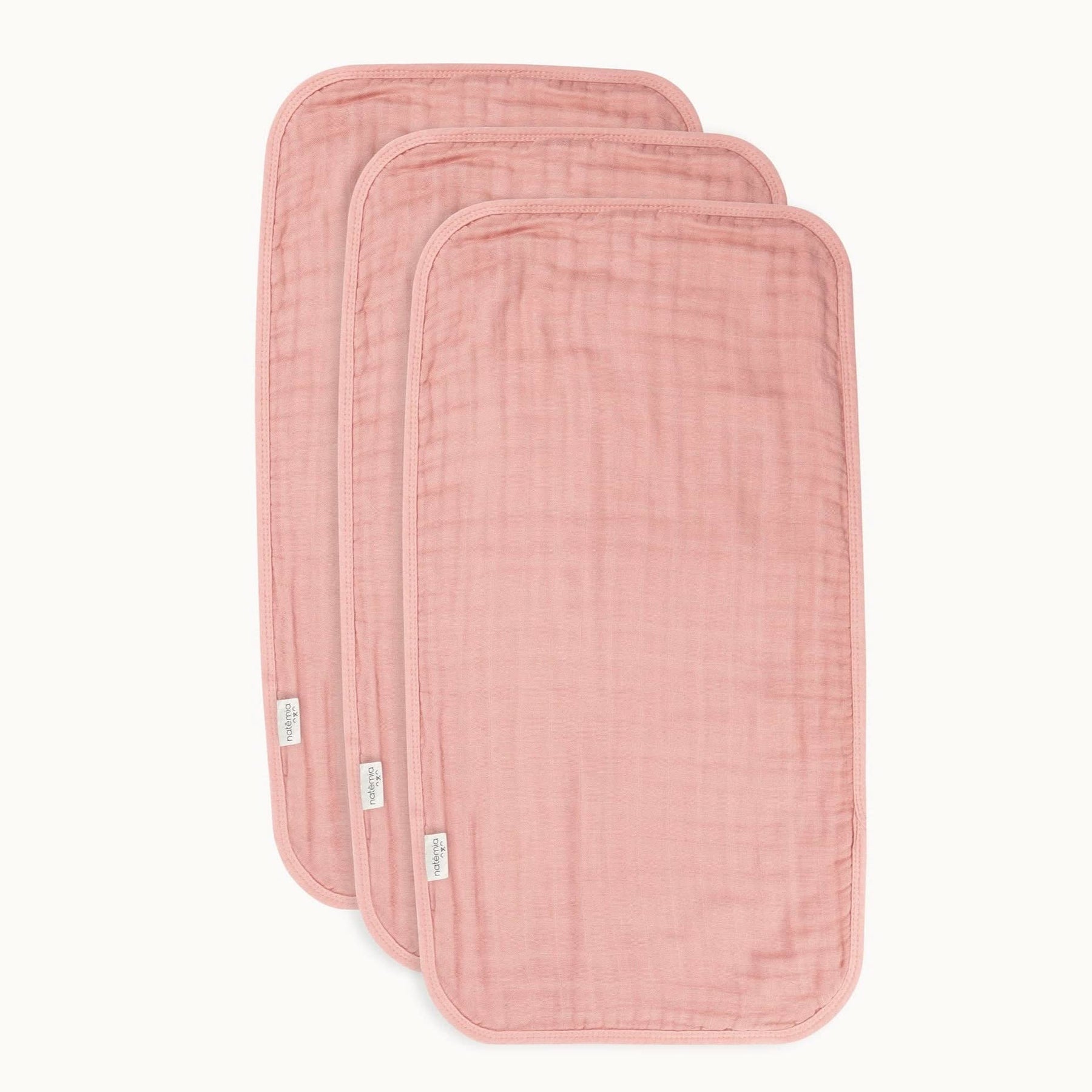 Dusty pink muslin burp cloths, soft and absorbent, set of three for baby care.