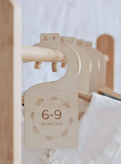 Set of wooden nursery closet dividers engraved with age labels from newborn to 24 months